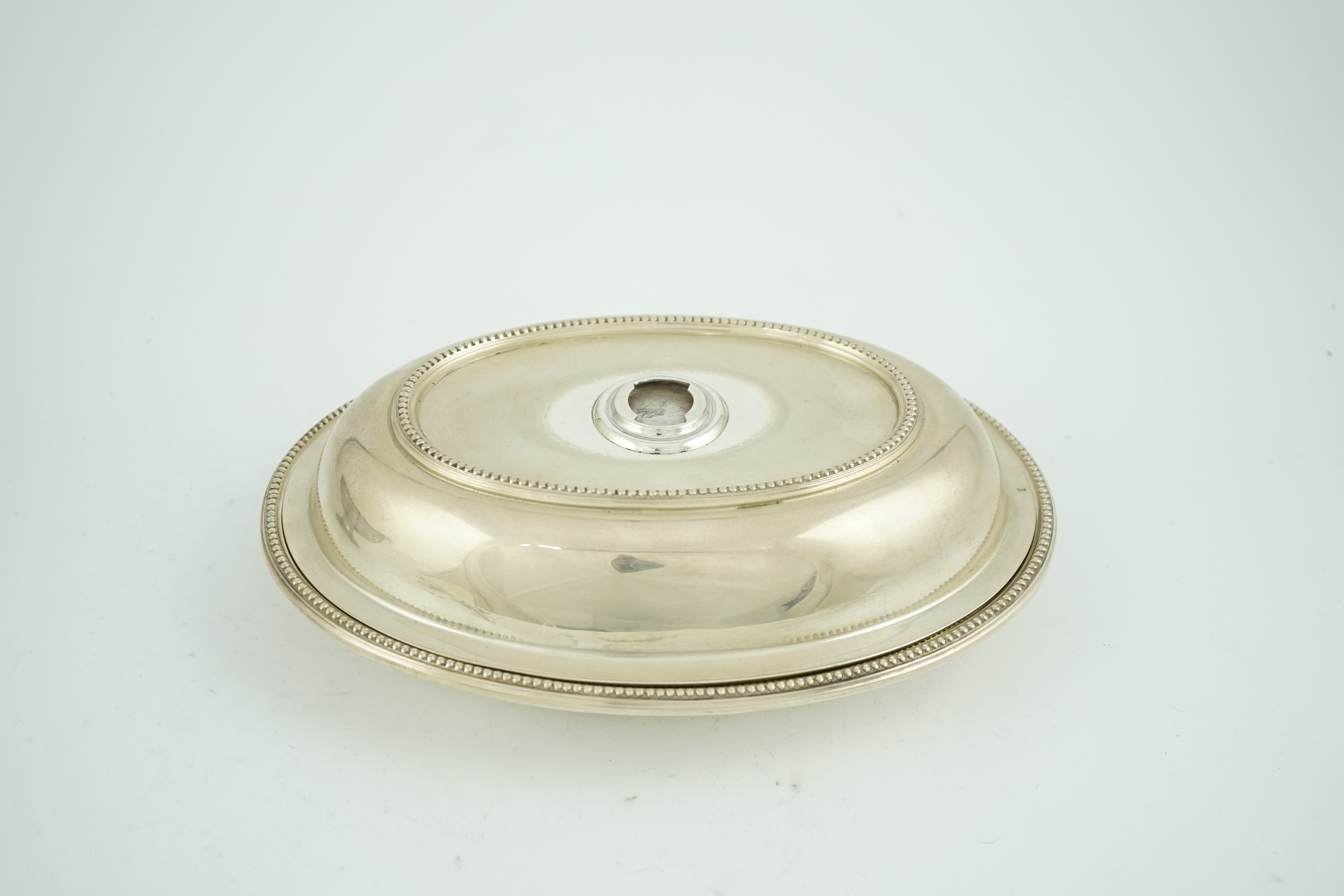 An Edwardian silver oval entreé dish and cover, lacking handle, by Goldsmiths & Silversmiths Co Ltd